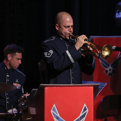 Photo of uniformed man playing trumpet